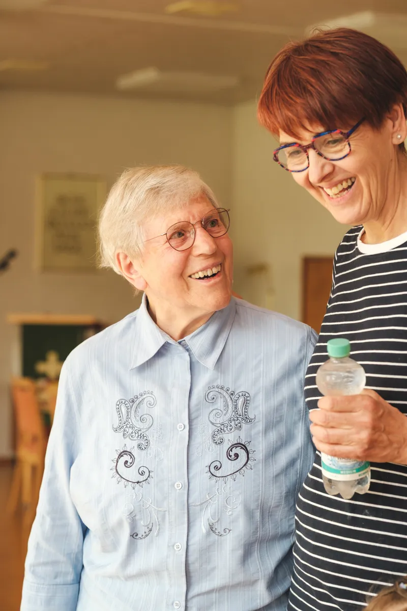 Zwei Frauen stehen nebeneinander und lachen