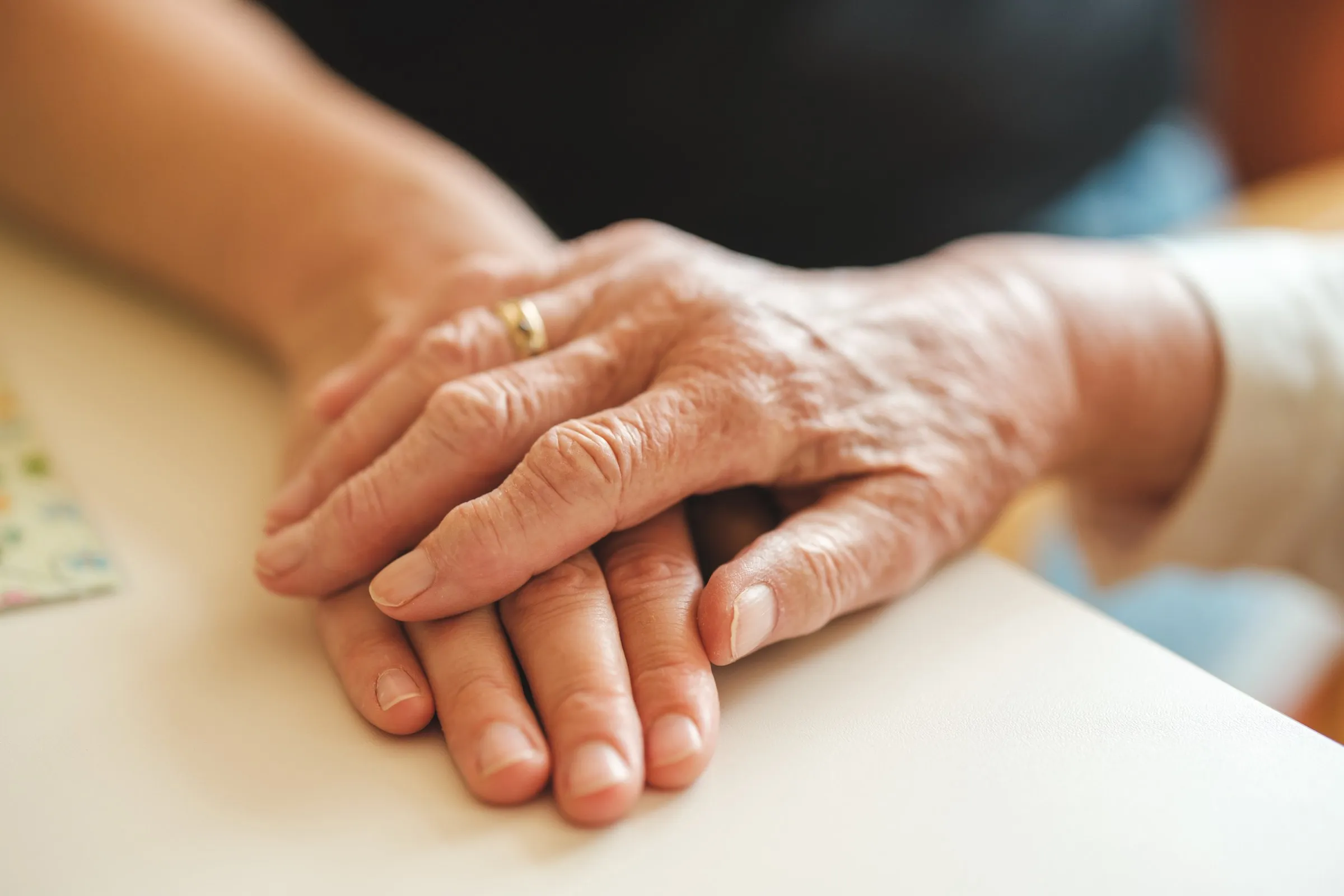 Eine Hand liegt auf der Hand einer älteren Person
