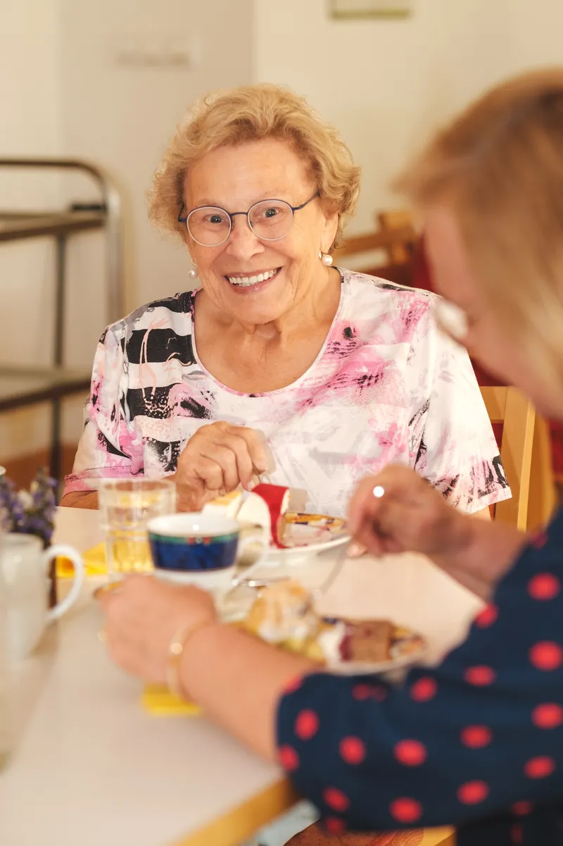 Zwei Frauen sitzen an einem Kaffeetisch im Gespräch