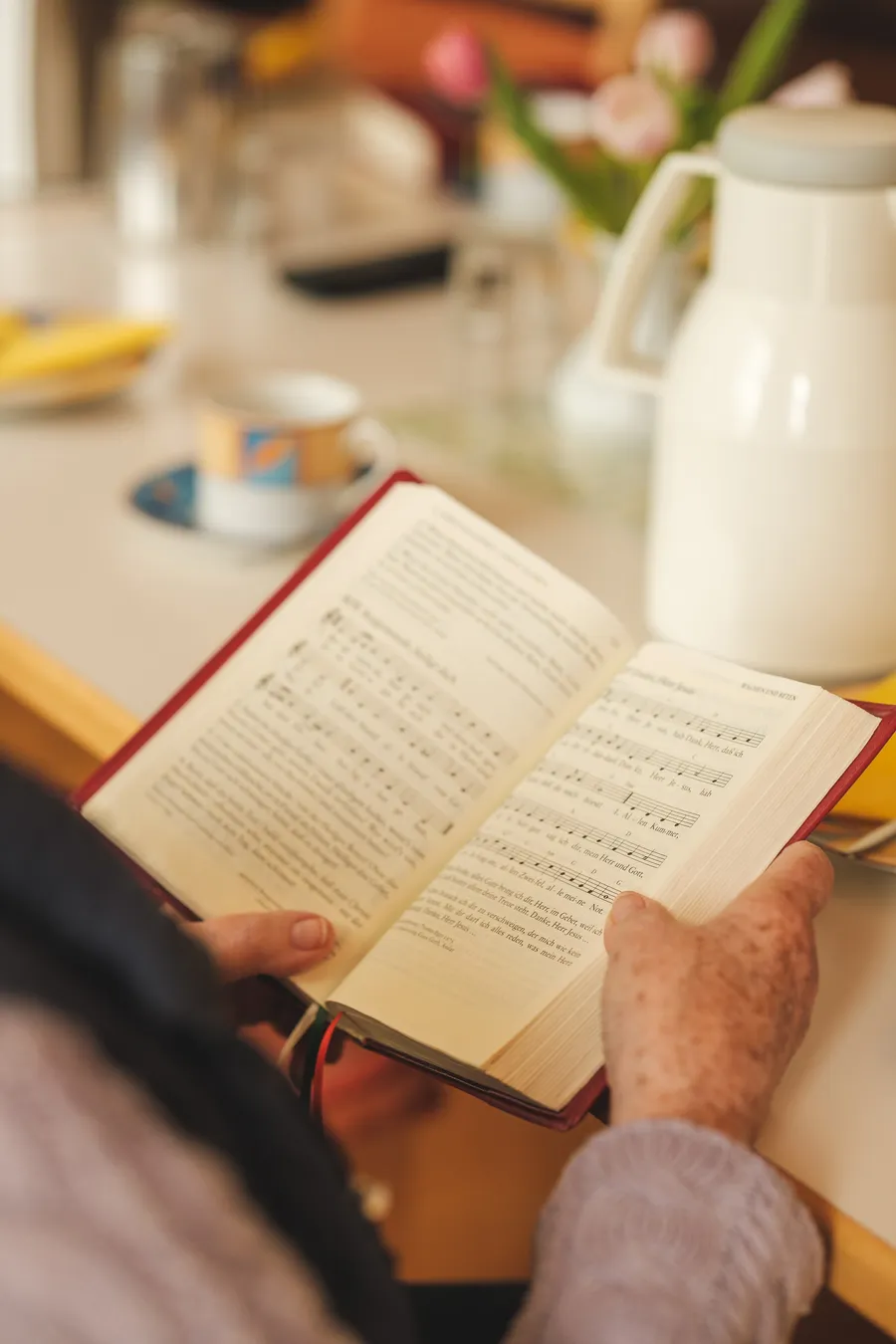 Ein aufgeschlagenes Liederbuch in zwei Händen