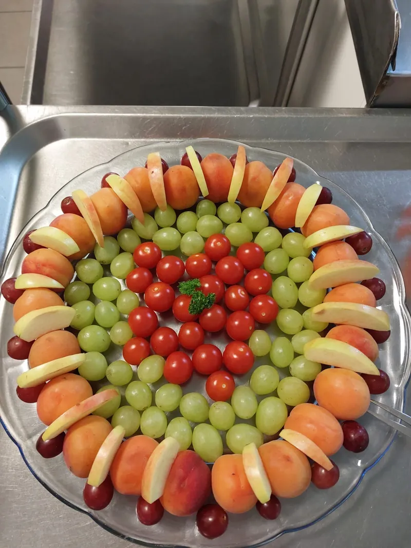 Obstplatte mit Aprikosen, Trauben, Tomaten und Apfelspalten