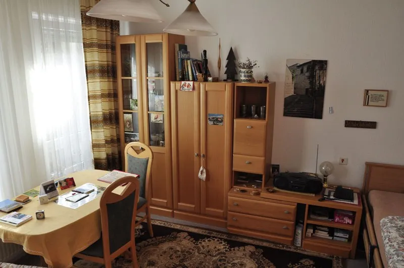 Zimmer mit Schrankwand, Tisch und Schreibtisch